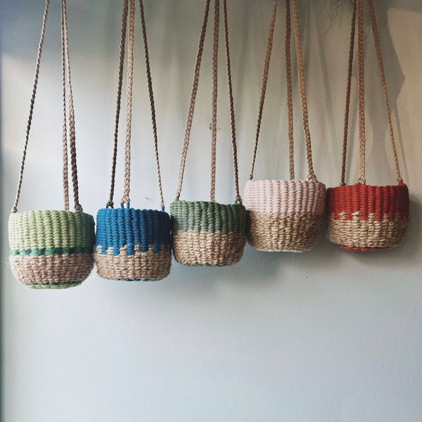 5 small hanging baskets against a light blue background in natural and bright colours of blue, light and dark green, blush and rust